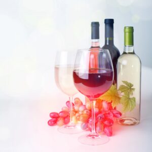 wineglass, bottles of wine and grapes